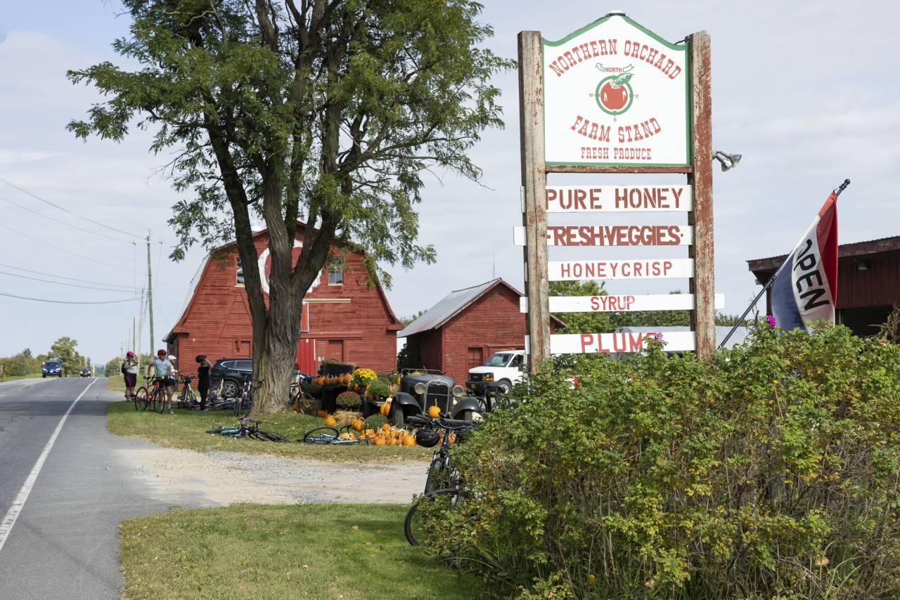 A red barn and farm that sells honey and fresh veggies.